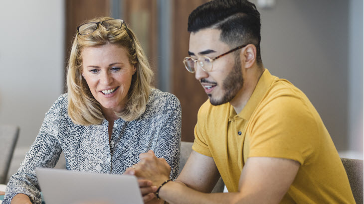 Two colleagues looking at a laptop